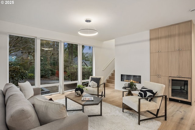 living area with a glass covered fireplace and light wood-style flooring