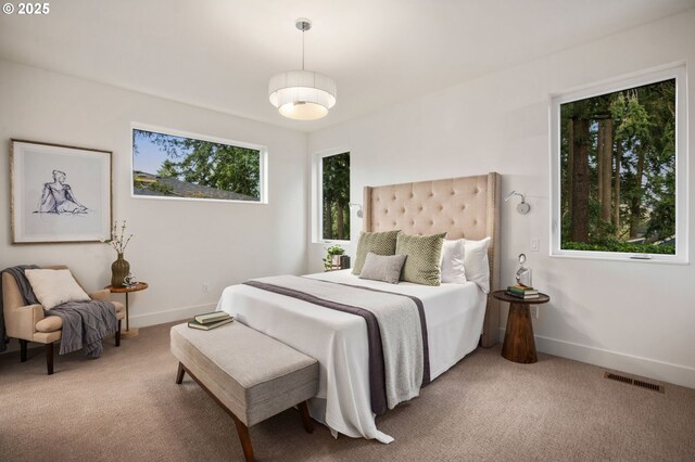 carpeted bedroom featuring baseboards and visible vents