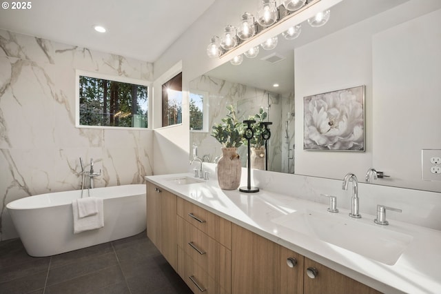 full bathroom with a freestanding bath, double vanity, visible vents, and a sink