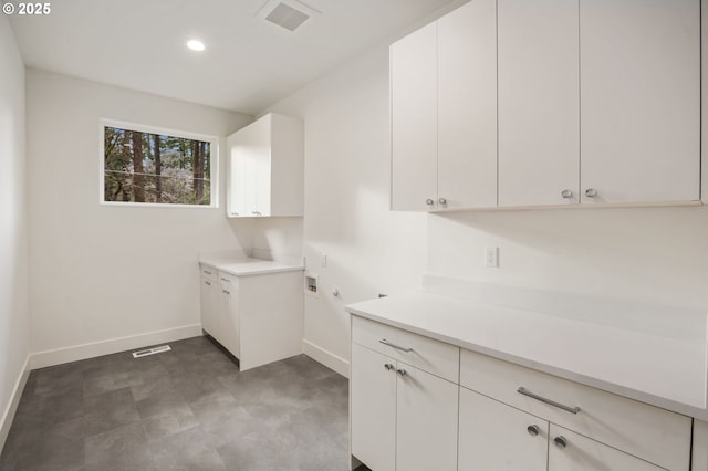 laundry area with washer hookup, cabinet space, visible vents, and baseboards