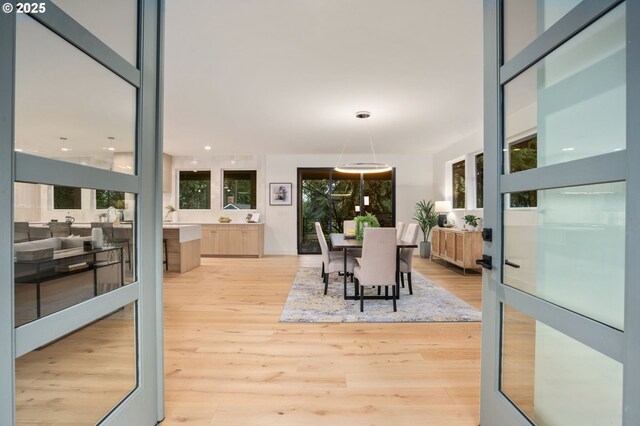 kitchen featuring modern cabinets, tasteful backsplash, light wood-style floors, a breakfast bar area, and light countertops