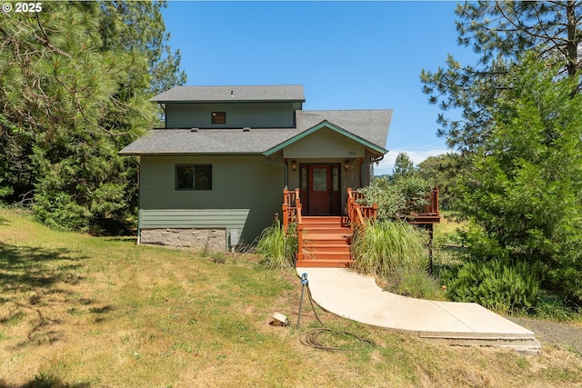 view of front of home featuring a front yard and roof with shingles