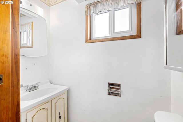 bathroom with toilet, a wealth of natural light, and vanity