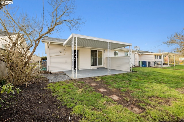 back of property with a patio, a lawn, and fence