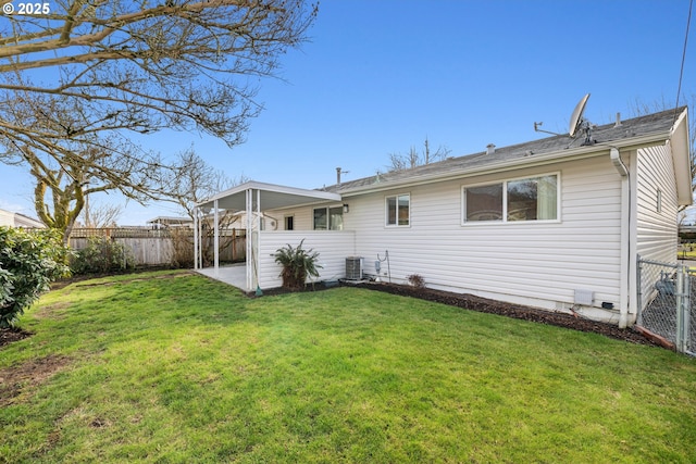 back of house with central air condition unit, a fenced backyard, and a lawn