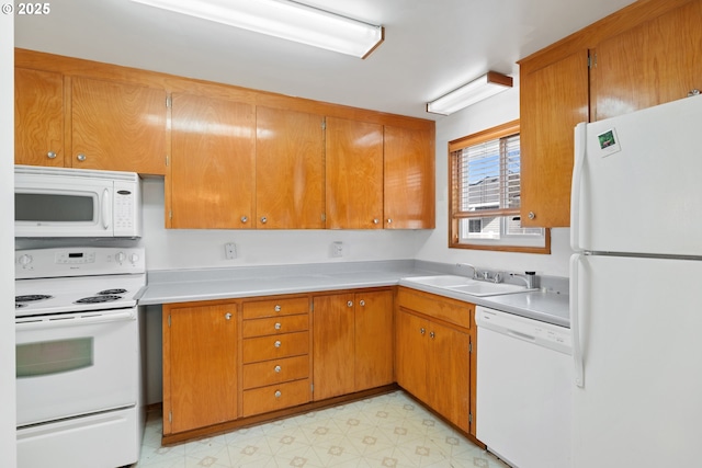 kitchen featuring white appliances, a sink, light countertops, brown cabinets, and light floors