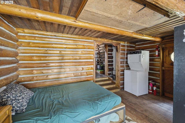 bedroom with stacked washing machine and dryer, rustic walls, hardwood / wood-style flooring, and wood ceiling