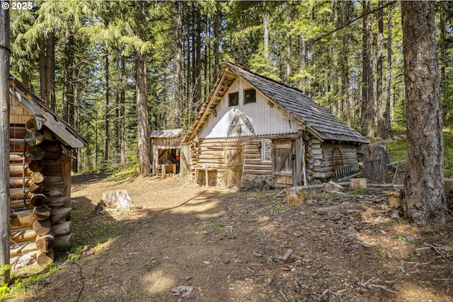 view of outdoor structure with an outbuilding and a forest view