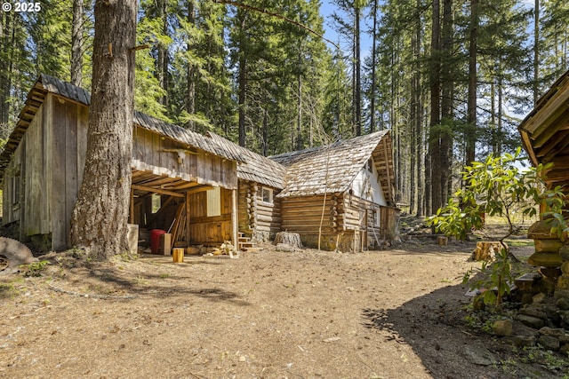 view of home's exterior featuring log siding and an outdoor structure