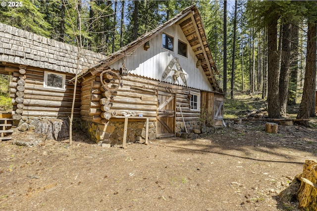 back of property with log exterior, an outbuilding, and a barn