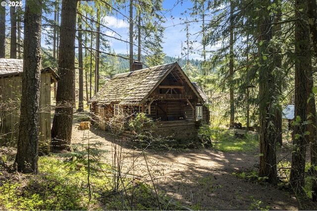 view of outbuilding featuring a view of trees