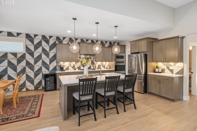 kitchen featuring light countertops, beverage cooler, decorative backsplash, and stainless steel appliances