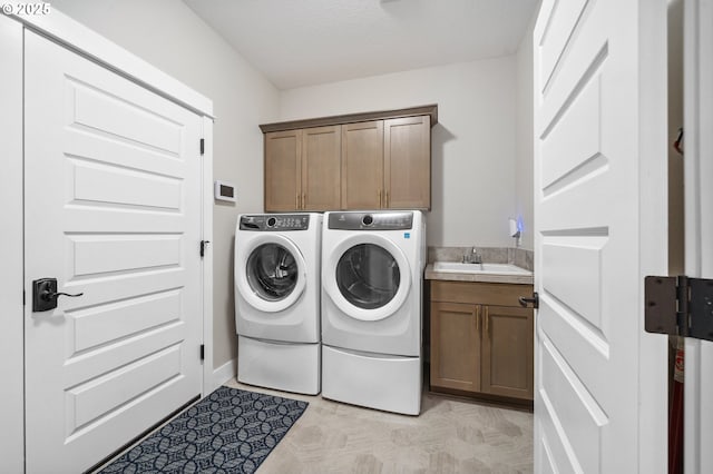 laundry room featuring washer and clothes dryer, a sink, and cabinet space