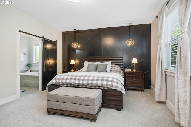 carpeted bedroom with a barn door, baseboards, and multiple windows