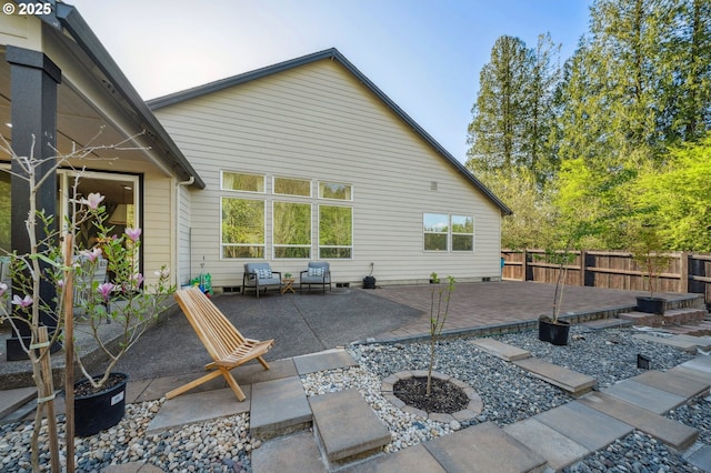 rear view of property with fence, a patio area, and a fire pit
