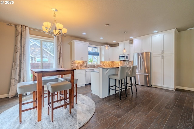 11201 NE 127th Ave, Vancouver, WA 98682 - kitchen featuring stainless steel appliances, dark wood-style flooring, a chandelier, tasteful backsplash, and white cabinetry