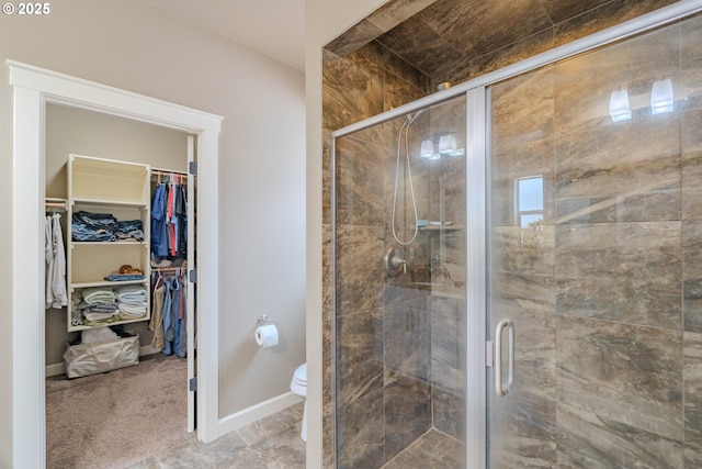11201 NE 127th Ave, Vancouver, WA 98682 - bathroom with a shower stall, a walk in closet, toilet, and baseboards