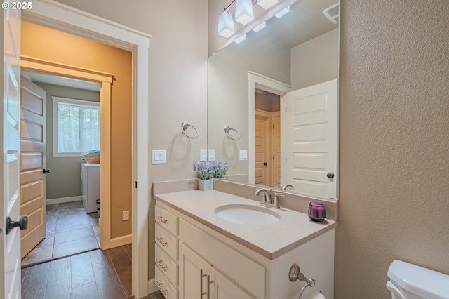 11201 NE 127th Ave, Vancouver, WA 98682 - half bath with wood finished floors, vanity, toilet, a textured wall, and baseboards