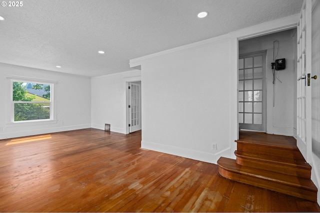 322 W C St, Rainier, OR 97048 - empty room with a textured ceiling, recessed lighting, wood finished floors, french doors, and stairs