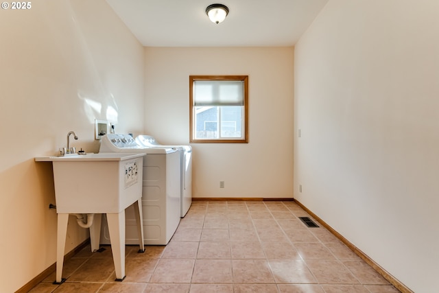 laundry area featuring light tile patterned flooring, laundry area, separate washer and dryer, visible vents, and baseboards