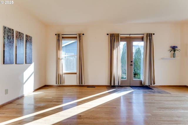 entryway featuring light wood finished floors, visible vents, baseboards, and french doors