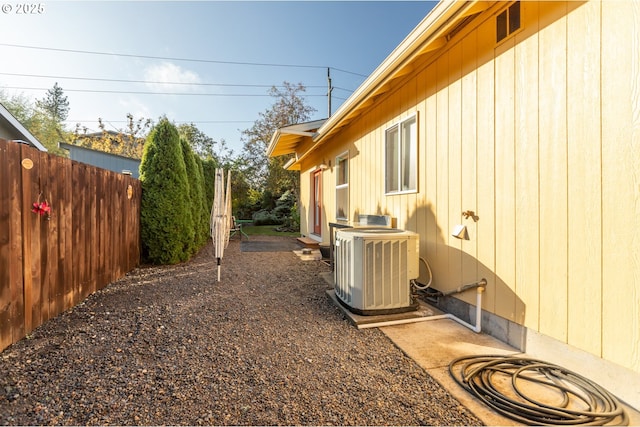 exterior space featuring central AC and fence