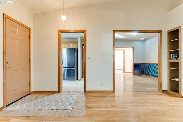 foyer with light wood-type flooring and baseboards