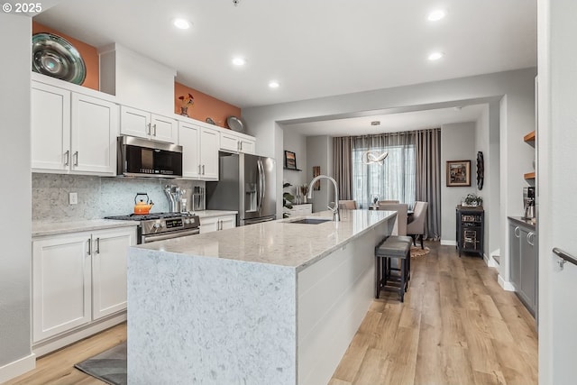 kitchen featuring white cabinetry, an island with sink, appliances with stainless steel finishes, and sink