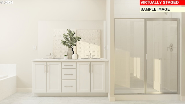 bathroom featuring double vanity, a garden tub, a shower stall, and a sink