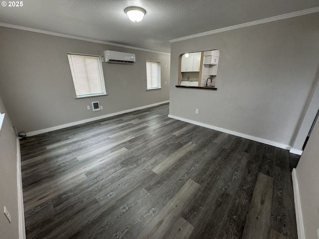 unfurnished room featuring a textured ceiling, dark wood-type flooring, a wall mounted air conditioner, and crown molding