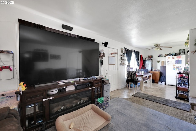 tiled living room featuring ceiling fan and a textured ceiling