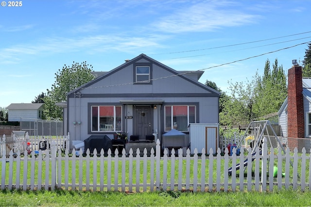bungalow-style home featuring a fenced front yard and a front yard