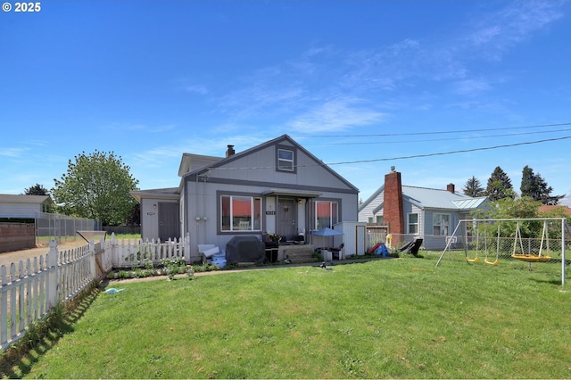 back of house with a lawn and a fenced backyard