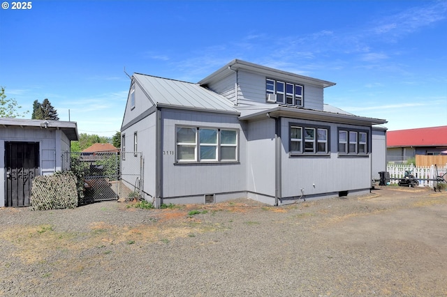 view of front of home with fence, a standing seam roof, crawl space, and metal roof