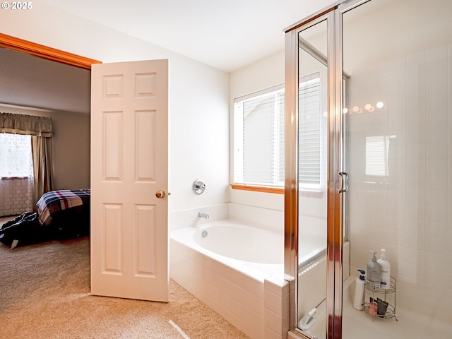 ensuite bathroom with ensuite bathroom, a wealth of natural light, a shower stall, and a garden tub