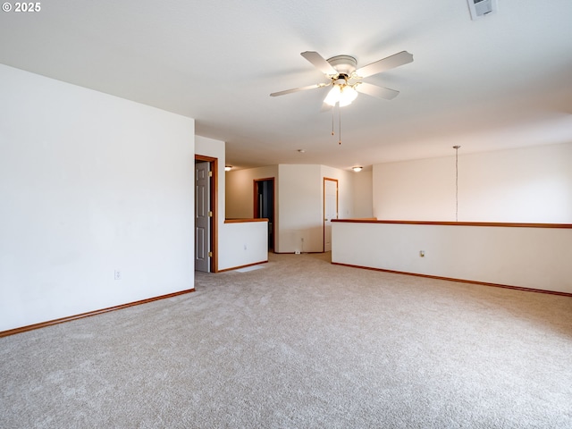 empty room featuring visible vents, baseboards, a ceiling fan, and light colored carpet