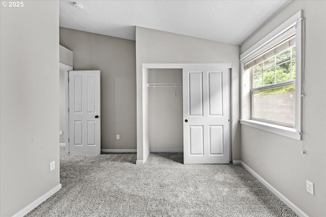 9183 NW Germantown Rd, Portland, OR 97231 - unfurnished bedroom featuring carpet, a closet, a textured ceiling, baseboards, and lofted ceiling