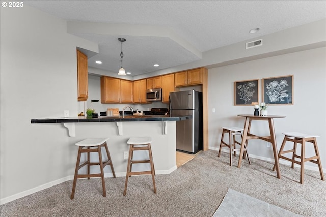 9183 NW Germantown Rd, Portland, OR 97231 - kitchen with stainless steel appliances, a kitchen breakfast bar, light carpet, a peninsula, and a sink