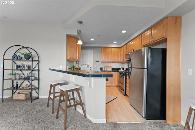 9183 NW Germantown Rd, Portland, OR 97231 - kitchen featuring stainless steel appliances, dark countertops, a peninsula, a breakfast bar area, and a textured ceiling
