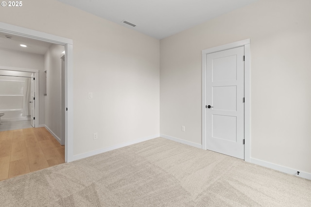 unfurnished room with light carpet, baseboards, and visible vents