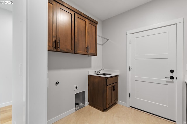 laundry area featuring a sink, electric dryer hookup, cabinet space, and baseboards