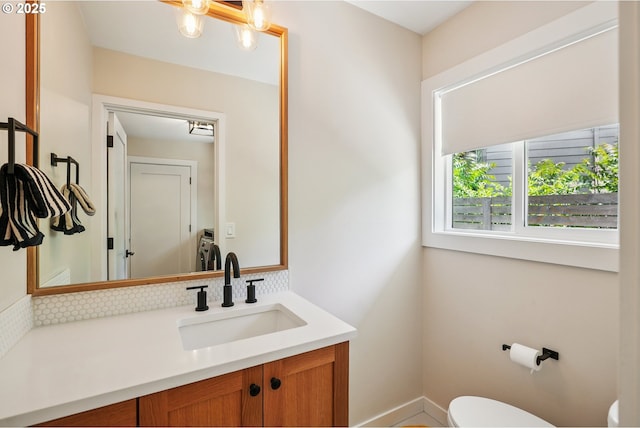 10559 NE Thompson St, Portland, OR 97220 - bathroom with toilet, tasteful backsplash, vanity, and baseboards