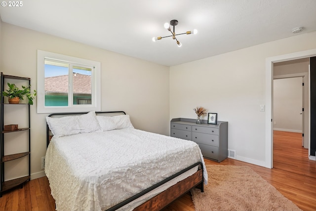 10559 NE Thompson St, Portland, OR 97220 - bedroom with a chandelier, wood finished floors, and baseboards