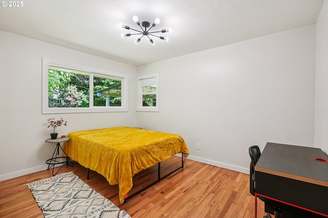 10559 NE Thompson St, Portland, OR 97220 - bedroom with a chandelier, light wood-type flooring, and baseboards