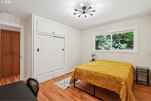 10559 NE Thompson St, Portland, OR 97220 - bedroom featuring light wood-style floors, a chandelier, a closet, and baseboards