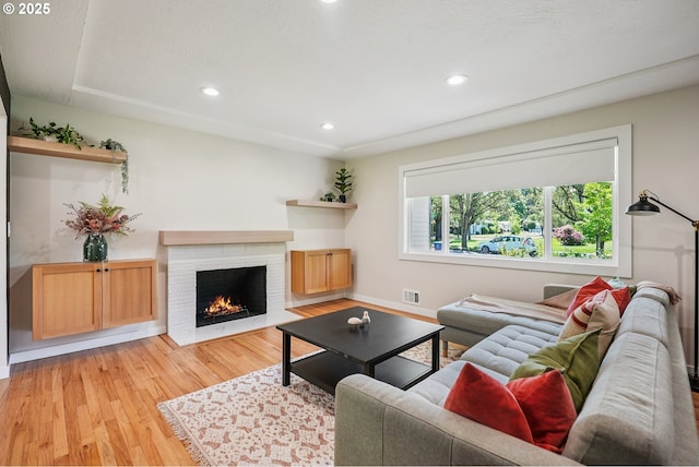 10559 NE Thompson St, Portland, OR 97220 - living room featuring light wood-style flooring, recessed lighting, a fireplace, and baseboards