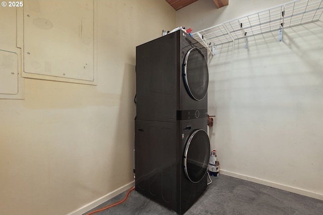 laundry room with stacked washer / dryer, baseboards, and electric panel