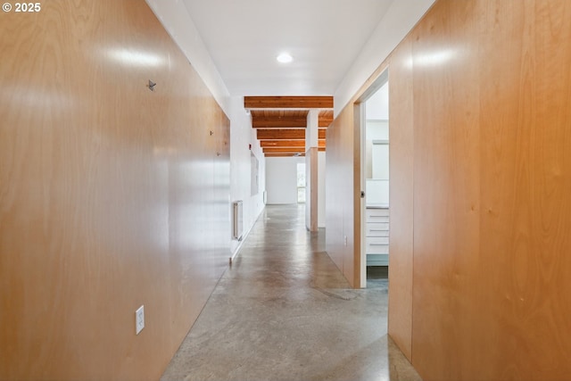 corridor featuring concrete flooring, recessed lighting, and beamed ceiling