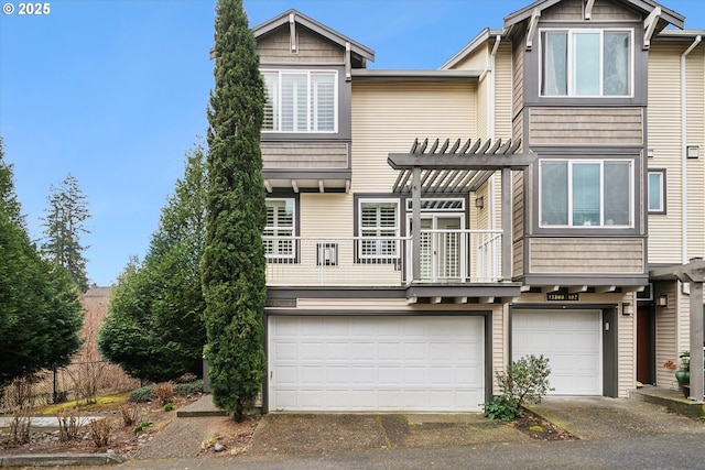 view of property featuring a garage, driveway, and a pergola