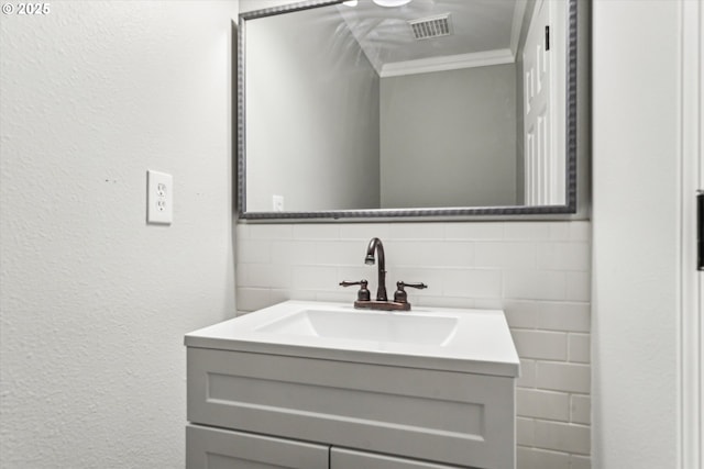 bathroom with tile walls, visible vents, crown molding, and vanity